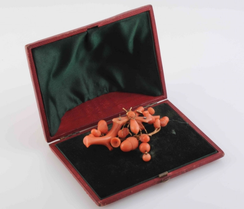 A MID 19TH CENTURY CORAL BROOCH, ornately carved to depict a branch with multiple acorn highlights, set to the centre with a winged insect with two old cut diamond highlights to the wings and gold work highlights for the legs and head, set on brooch pin f