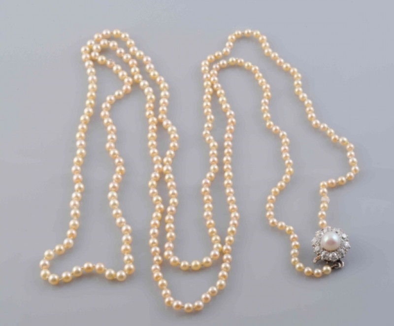 A NATURAL SALTWATER PEARL NECKLACE, each uniform seed pearl strung knotted onto a later added integral clasp set with a single cultured pearl within a surround of ten old brilliant cut diamonds. Total length 107cm. Weight 16.1 grams.  With GCS Pearl Repor
