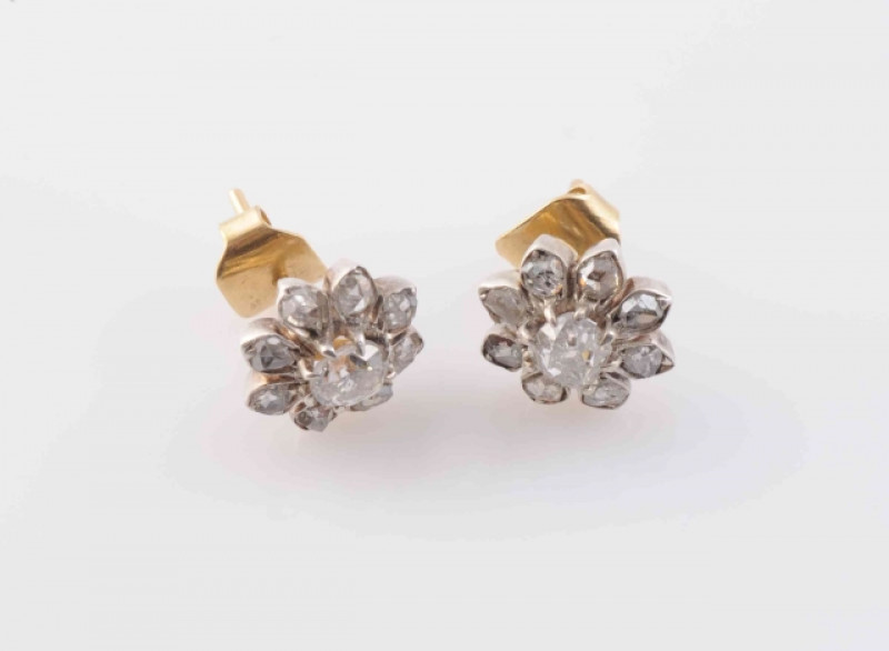A PAIR OF DIAMOND STUD EARRINGS, formed as a flower head, set to the centre with a single old cushion cut diamond within a surround of eight petal shaped mounts each set with a single old cut diamond highlight, on post and scroll fittings. Total weight 3.
