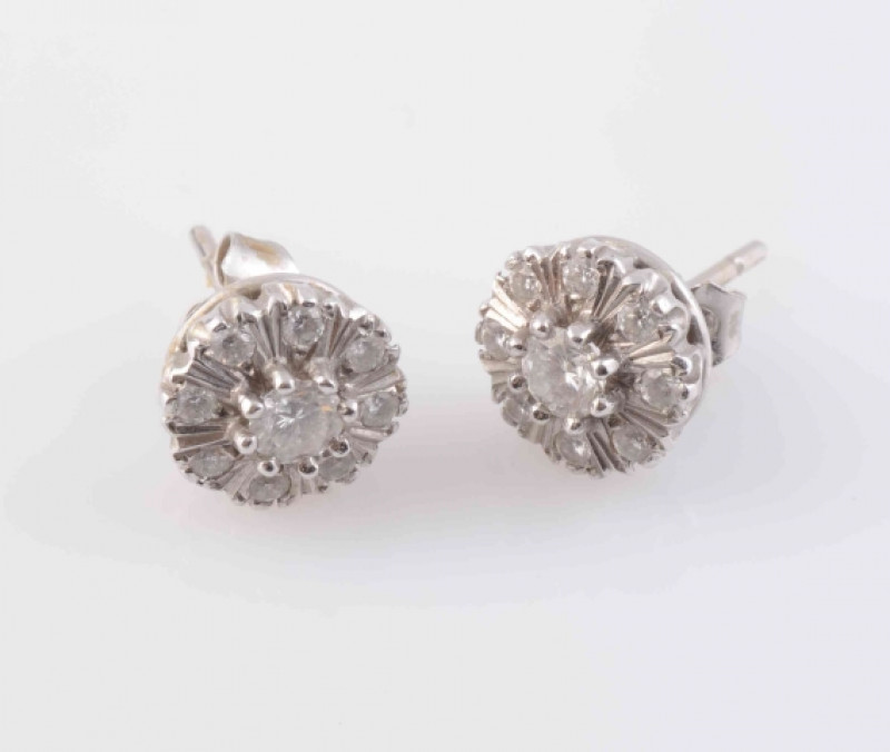 A PAIR OF DIAMOND STUD EARRINGS, the central brilliant cut diamond raised slightly within a surround of eight smaller brilliant cut diamonds with moulded metal details, on post and scroll fittings. Scroll stamped 750. Weight 3.7 grams.