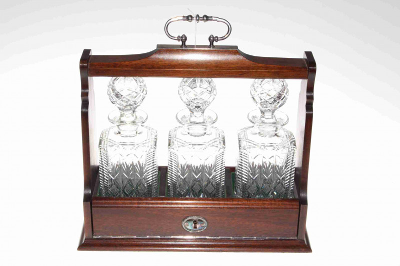 Mahogany three bottle tantalus fitted with three matching cut glass decanters