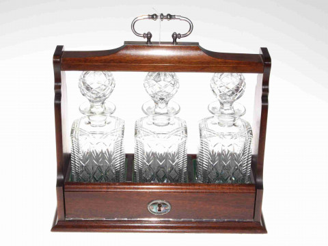 Mahogany three bottle tantalus fitted with three matching cut glass decanters