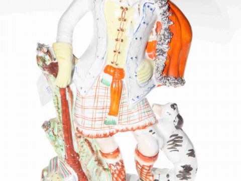 Staffordshire figure of Scotsman with gun, game and hound