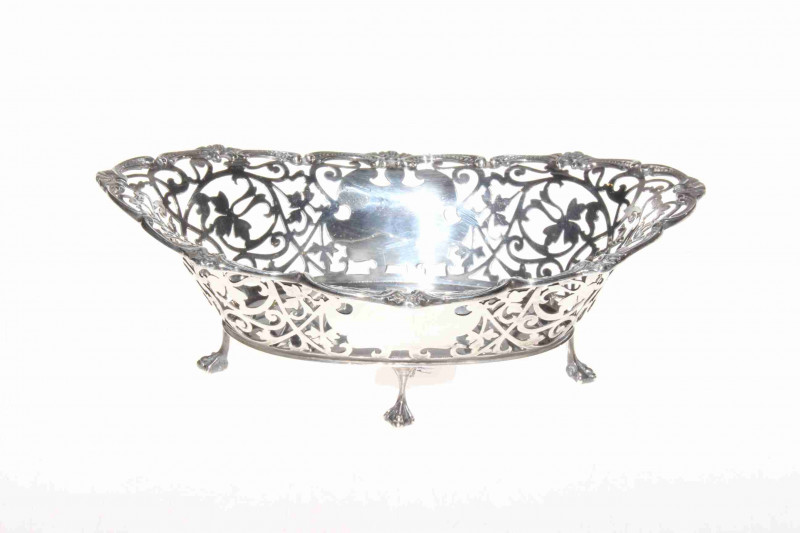 Edwardian silver basket on four feet, the pierced body with scroll border, London 1901