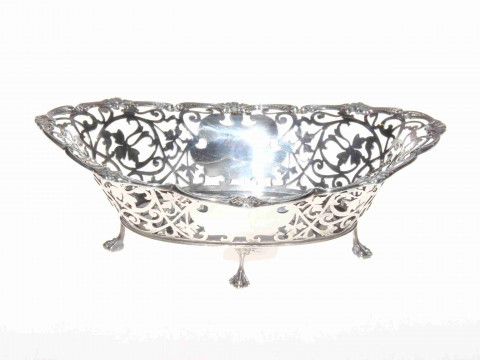 Edwardian silver basket on four feet, the pierced body with scroll border,...