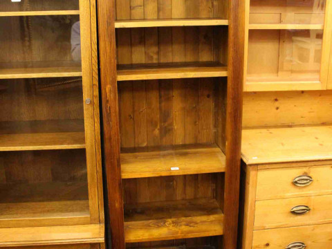 Slim stained pine open bookcase having four adjustable shelves above a...