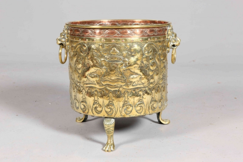A HANDSOME BRASS AND COPPER PLANTER, repousse with lions, mounted figure and foliage. 44.5cm high