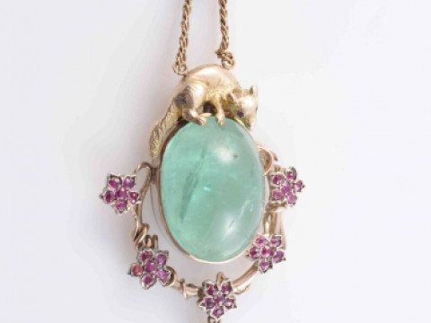 AN EMERALD AND RUBY PENDANT, the large oval cabochon cut emerald collet...