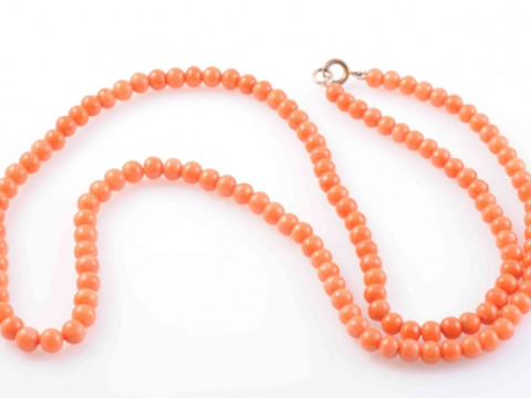 A CORAL NECKLACE, the one hundred and thirty-two polished coral beads...