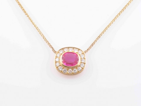 A RUBY AND DIAMOND PENDANT, the oval mixed cut ruby collet set within...