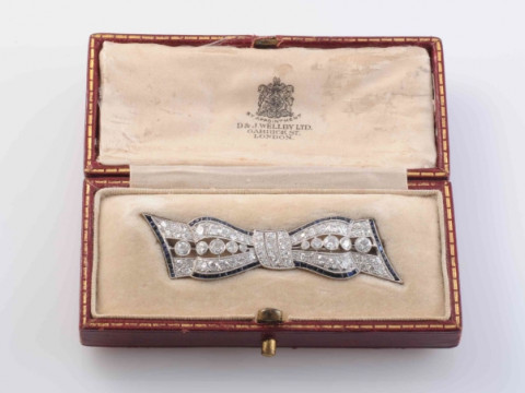 AN EDWARDIAN DIAMOND AND SAPPHIRE BROOCH, modelled as a bow, set to the...