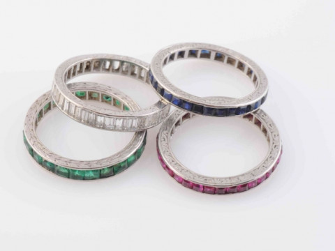 A SET OF FOUR ETERNITY RINGS, to include a ring set throughout with baguette...
