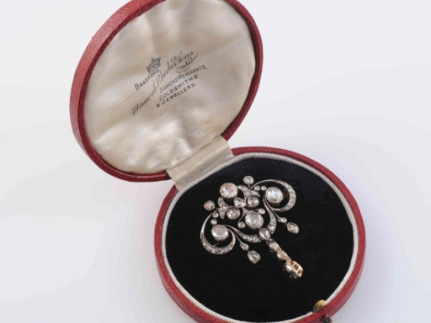 AN EDWARDIAN DIAMOND BROOCH, the symmetrical mount of delicate scroll...