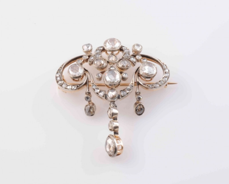 AN EDWARDIAN DIAMOND BROOCH, the symmetrical mount of delicate scroll and floral details suspending three graduating articulated drops, set with five principal round mixed cut collet set diamonds, and a further forty-four graduating old mixed diamond high
