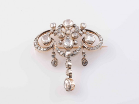 AN EDWARDIAN DIAMOND BROOCH, the symmetrical mount of delicate scroll and floral details suspending three graduating articulated drops, set with five principal round mixed cut collet set diamonds, and a further forty-four graduating old mixed diamond high thumbnail