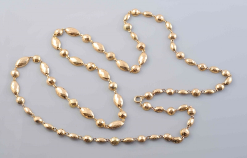 A GOLD COLOURED NECKLACE, formed of alternate circular and oval mounts with faceted detailing, each set on articulated links on bolt ring clasp. Total length 83cm. Weight 23.6 grams.