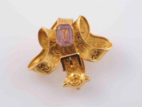 AN EARLY 19TH CENTURY TOPAZ SET BROOCH, the symmetrical scrolling bow...