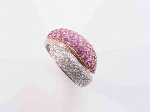 A DIAMOND AND PINK TOPAZ RING, the crossover style mount set to one side...