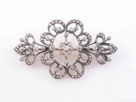AN EDWARDIAN DIAMOND BROOCH, the symmetrical scrolling and delicate floral...