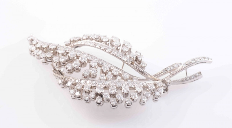 A DIAMOND SET BROOCH, formed as a floral spray, set throughout with seventy-five brilliant cut individually claw set diamonds and a further sixty one graduating brilliant cut diamonds set to the stems (one lacking), on brooch pin fitting. Stamped 750. Len
