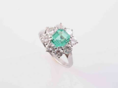 A COLOMBIAN EMERALD AND DIAMOND RING, the square cut emerald four double...
