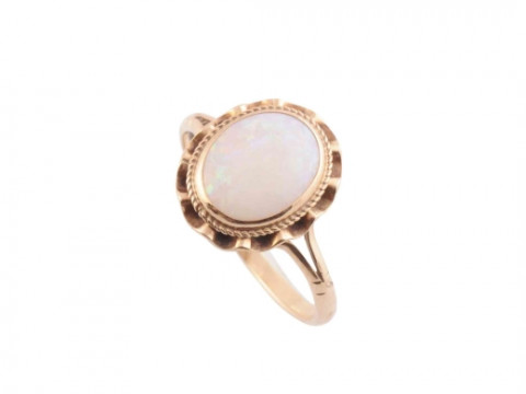 AN OPAL RING, the oval cut opal collet set to the centre of a delicate...