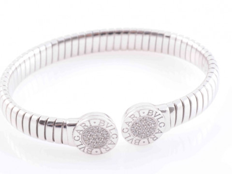 A DIAMOND SET BANGLE BY BULGARI, the circular end terminals set to the...