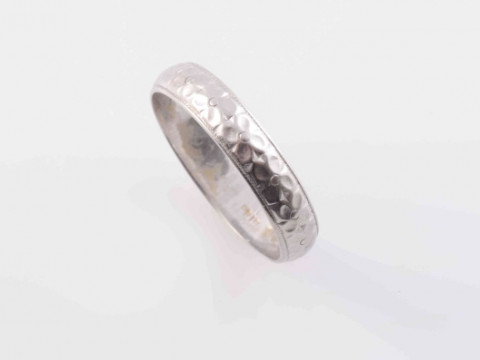 A DIAMOND RING, the single brilliant cut diamond four claw set in a heavy square shaped mount between solid moulded tapering shoulders on a plain band. Ring size M½; AND A WHITE METAL RING, the curved band with engraved floral detailing to the entirety. R thumbnail