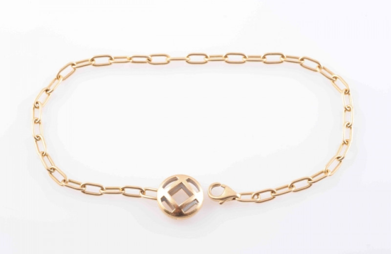 A YELLOW GOLD BRACELET BY CARTIER, of simple chain link form, with lobster catch and unusual circular pendant tag with cut-out detailing. Signed Cartier. Marked 750. Length 21cm. Weight 6.7gms.