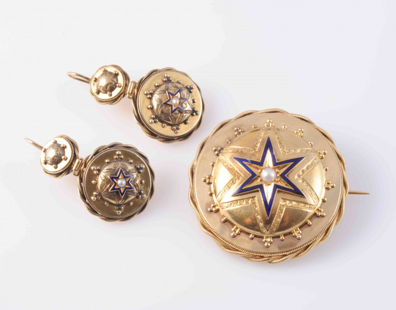 A MID VICTORIAN BROOCH AND EARRING DEMI-PARURE, the circular mounts with subtle beaded and rope work metal detailing, set to the centre with domed mounts set with enamel star shape design and engraved detailing, the brooch with brooch pin fitting and glas