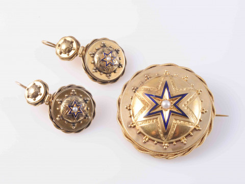 A MID VICTORIAN BROOCH AND EARRING DEMI-PARURE, the circular mounts with subtle beaded and rope work metal detailing, set to the centre with domed mounts set with enamel star shape design and engraved detailing, the brooch with brooch pin fitting and glas thumbnail