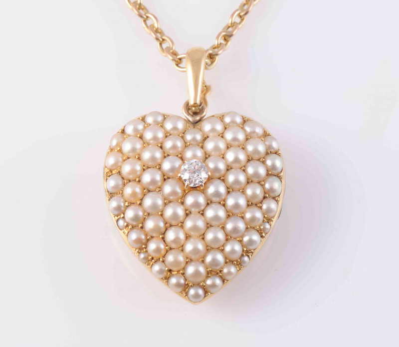 A LATE VICTORIAN SEED PEARL AND DIAMOND LOCKET PENDANT, the heart shaped mount set throughout with graduating seed pearls and a single diamond highlight to the centre, with glass locket to the reverse, all suspending from an articulated oval bale on fine