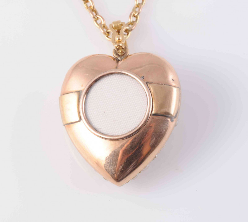 A LATE VICTORIAN SEED PEARL AND DIAMOND LOCKET PENDANT, the heart shaped mount set throughout with graduating seed pearls and a single diamond highlight to the centre, with glass locket to the reverse, all suspending from an articulated oval bale on fine