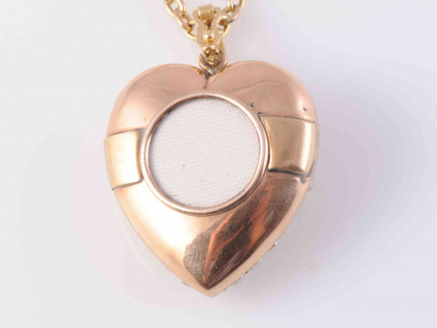 A LATE VICTORIAN SEED PEARL AND DIAMOND LOCKET PENDANT, the heart shaped mount set throughout with graduating seed pearls and a single diamond highlight to the centre, with glass locket to the reverse, all suspending from an articulated oval bale on fine thumbnail