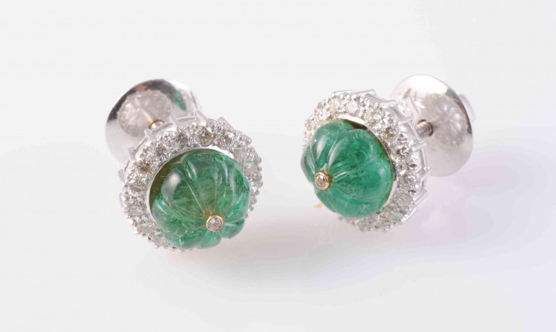 A PAIR OF EMERALD AND DIAMOND EARRINGS, the emerald bead engraved to depict six segments, set raised within a surround of sixteen brilliant cut diamonds, on simple closed back mounts with screw back fittings. Total weight 7.5gms.