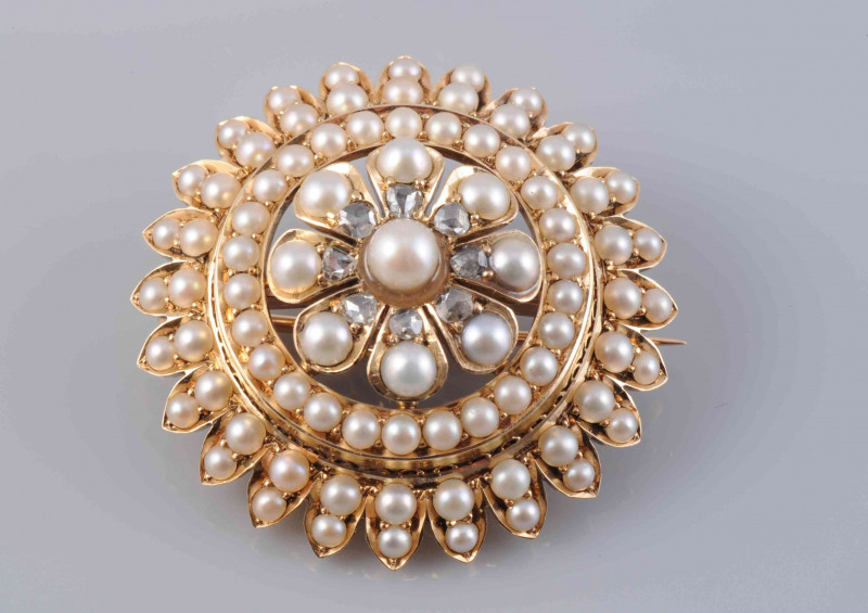 A SEED PEARL AND DIAMOND ROUNDEL BROOCH, circa 1880-1890, the domed and slightly stepped design with delicate pierced detailing to the centre, set throughout with graduating seed pearls and eight old cut diamond highlights, on detachable brooch pin fittin