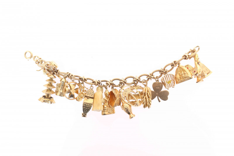 A 9 CARAT GOLD FANCY LINK CHARM BRACELET, with eighteen charms (many of which are stamped to indicate gold). Gross 74 grams, 20cm