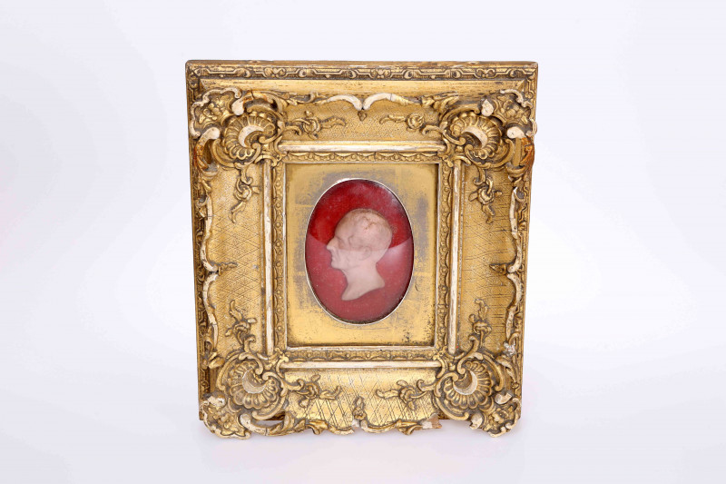 A VICTORIAN WAX PORTRAIT BUST, inscribed to old label verso Died April Thursday 14th 1859 at Mayfield, Walsall our dear friend *** aged 70, further inscription below God Father to Jane Margaret Haslewood, in a gilt-composition frame. Overall 25cm by 22cm