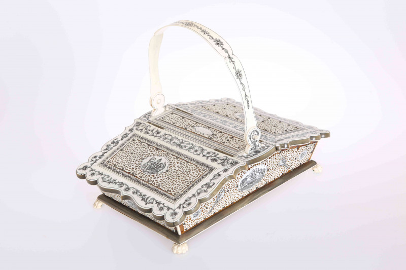 A FINE 19TH CENTURY ANGLO-INDIAN VIZAGAPATAM TWIN-LIDDED BASKET-SHAPED SEWING BOX, with swing handle, finely pierced and engraved ivory with foliate designs and deities, horn bandings, tortoiseshell on a sandalwood base, set on tiger paw feet. 31.5cm wide