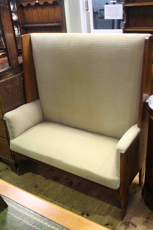 Arts & Crafts golden oak and upholstered hall settle, the sides carved with Glasgow style roses, 114cm wide