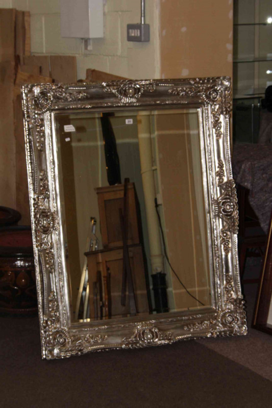 Ornate silvered framed bevelled wall mirror, 130cm by 103cm overall