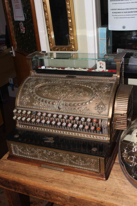 National Cash Register Company oak, brass and marble late Victorian cash register decorated with flowers, bells and scrolls, having 33 keys above a sliding drawer