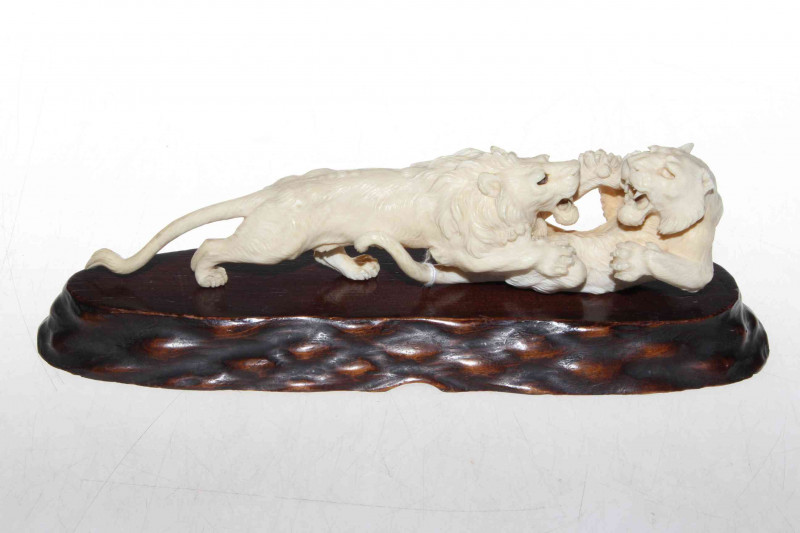 Antique Japanese carved ivory fighting lions, 23cm