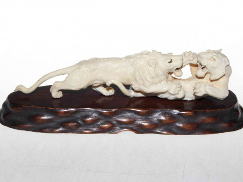 Antique Japanese carved ivory fighting lions, 23cm