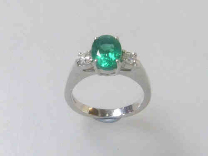 Emerald and Diamond Ring, the Emerald Estimated to Weigh 1.31 Carats, Between a Pair of Diamonds, on an 18ct White Gold Band, Size N