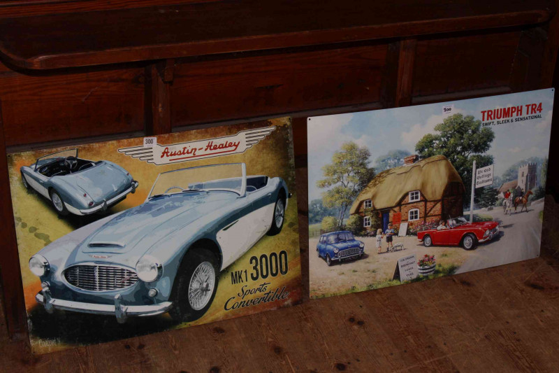 Two signs, Austin Healey and Triumph