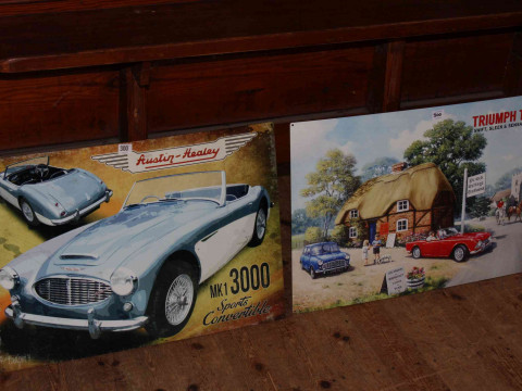 Two signs, Austin Healey and Triumph