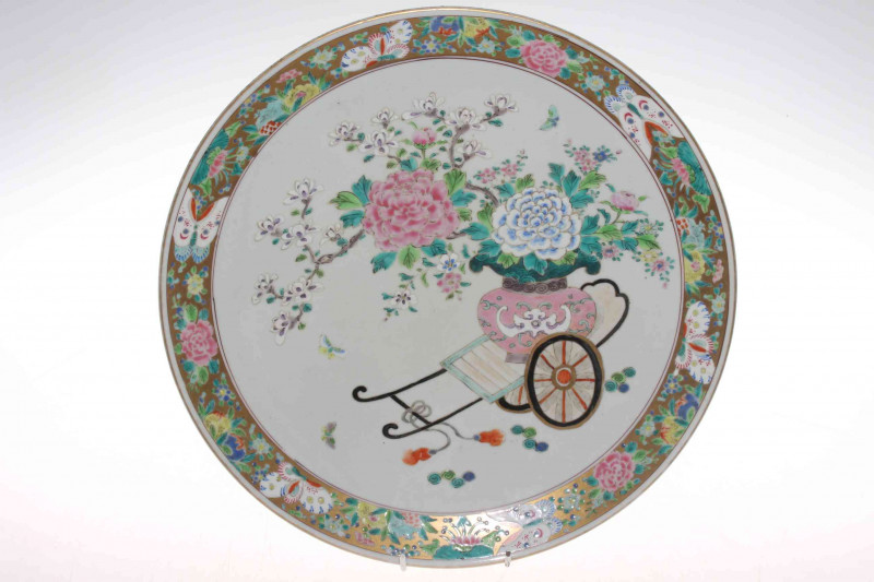 Japanese Meiji Period polychrome charger, painted with cart and jardiniere of flowers in famille rose, gilded decorated border, overglaze blue Fuka marks, 36.5cm diameter.