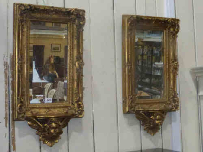 Pair of Gilt Framed Mirrors with shelf and cherub decoration