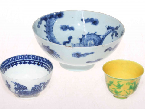 Three Chinese bowls, two are blue and white, the other is yellow and green,...